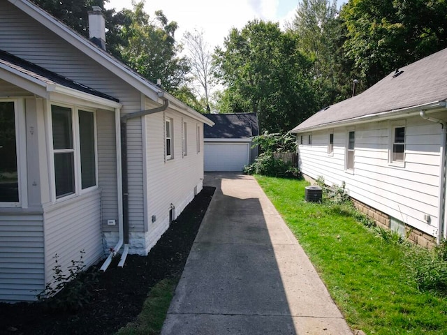 view of side of property featuring an outbuilding, a garage, and central AC unit