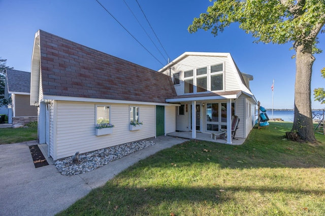 back of house featuring a lawn and a patio