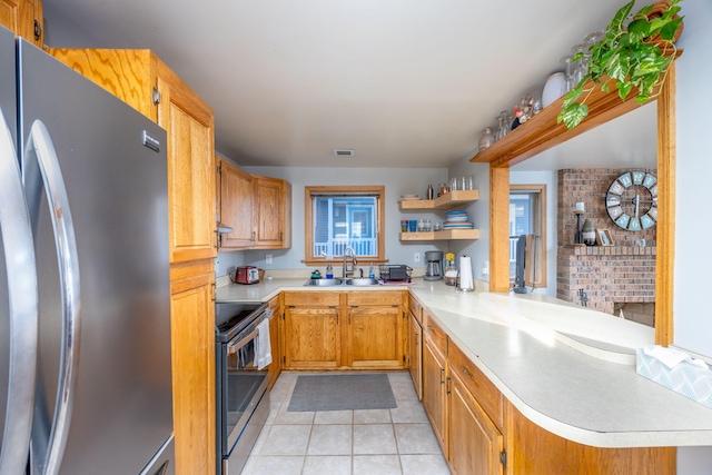 kitchen featuring kitchen peninsula, light tile patterned flooring, sink, and stainless steel appliances