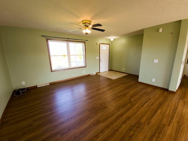 unfurnished room with ceiling fan, a textured ceiling, and dark hardwood / wood-style flooring