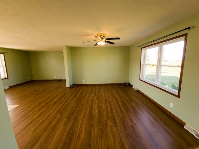 empty room featuring ceiling fan, a textured ceiling, and dark hardwood / wood-style flooring