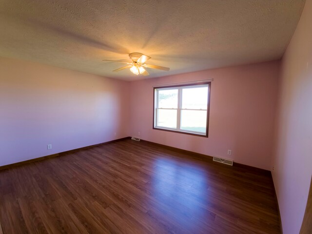 unfurnished room with ceiling fan, a textured ceiling, and dark hardwood / wood-style flooring