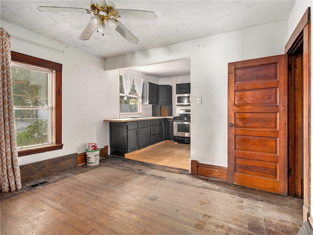 kitchen with hardwood / wood-style flooring, ceiling fan, and appliances with stainless steel finishes