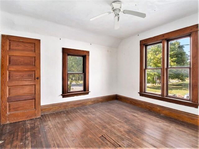 unfurnished room with dark hardwood / wood-style flooring, vaulted ceiling, and ceiling fan