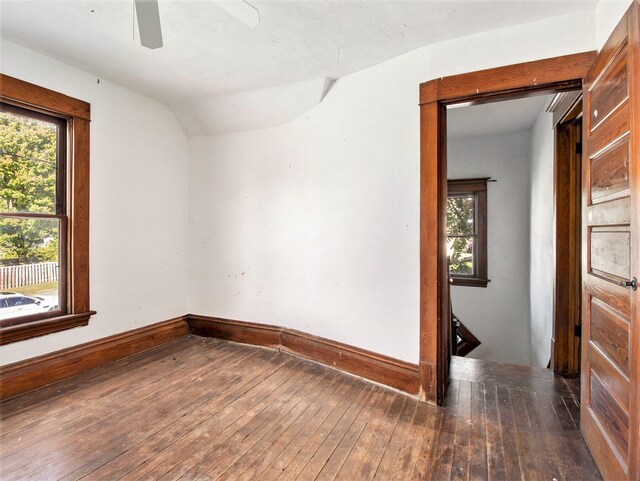 empty room featuring dark hardwood / wood-style flooring, a wealth of natural light, and vaulted ceiling