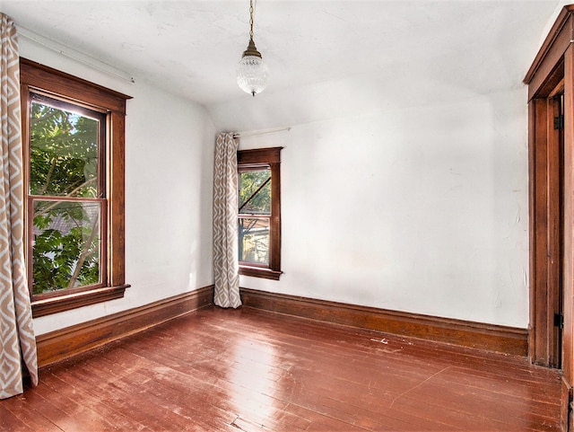 unfurnished room featuring dark hardwood / wood-style flooring and lofted ceiling