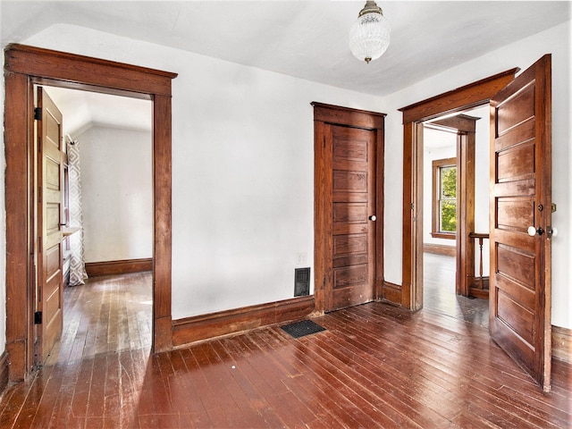 empty room featuring lofted ceiling and dark hardwood / wood-style floors