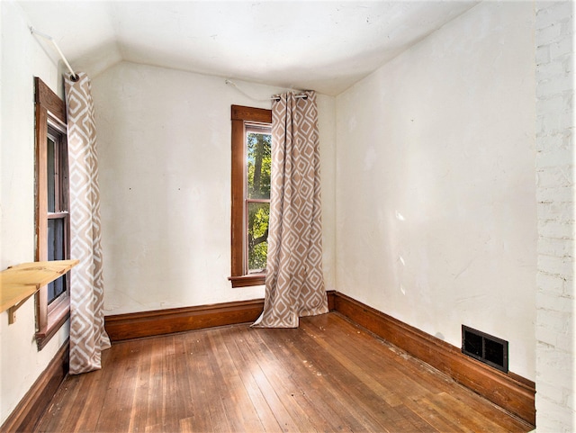 empty room featuring lofted ceiling and wood-type flooring