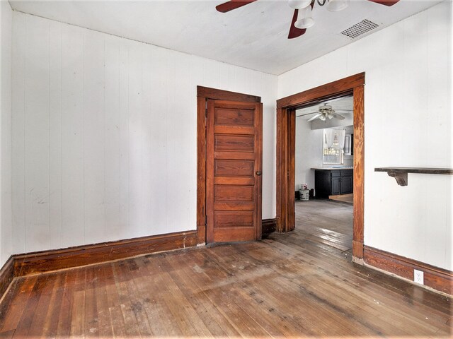 empty room featuring hardwood / wood-style flooring and wood walls