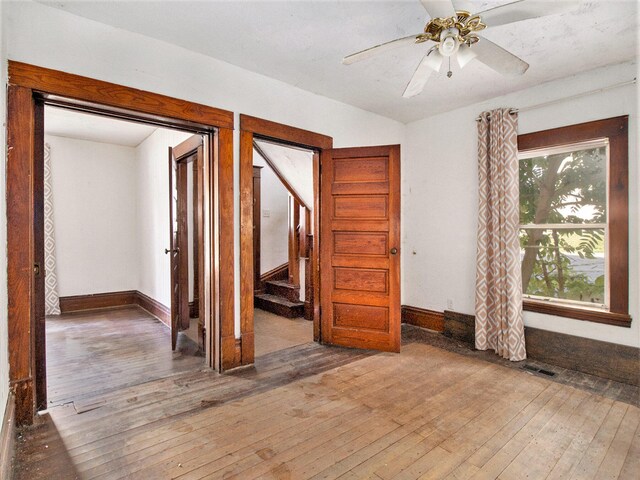 empty room with ceiling fan and wood-type flooring