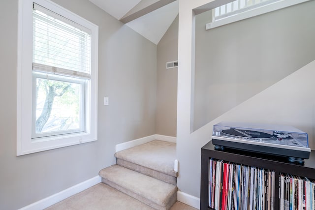 stairs featuring lofted ceiling and carpet flooring