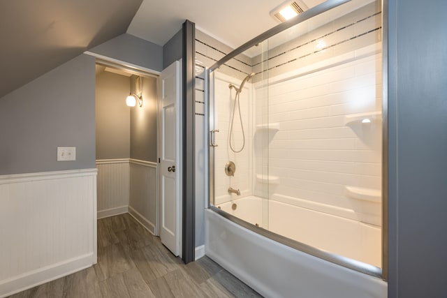 bathroom featuring vaulted ceiling and shower / bath combination with glass door