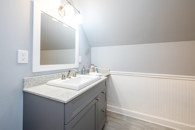 bathroom featuring vanity, lofted ceiling, and hardwood / wood-style floors