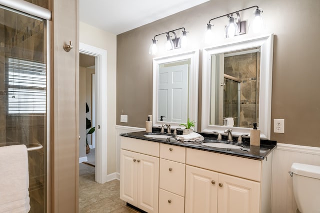 bathroom featuring tile patterned flooring, a shower with door, vanity, and toilet