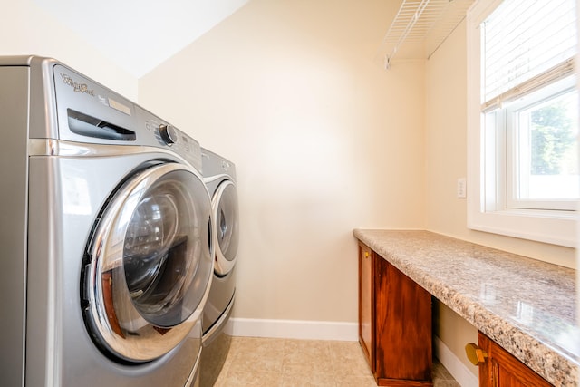 laundry room with washer and clothes dryer and light tile patterned flooring