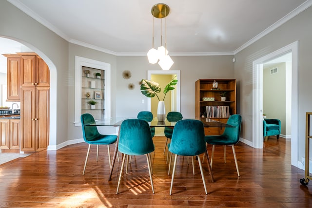 dining area featuring ornamental molding, built in shelves, dark wood-type flooring, and sink