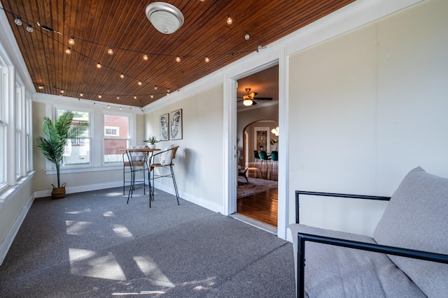 unfurnished sunroom featuring wooden ceiling and ceiling fan