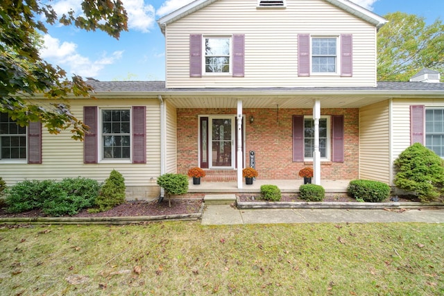 view of property with a front lawn and covered porch