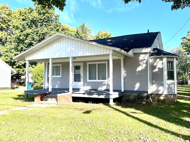 back of house featuring a yard and a porch