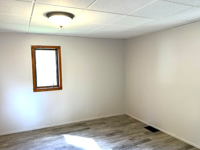 unfurnished room featuring hardwood / wood-style flooring and a drop ceiling