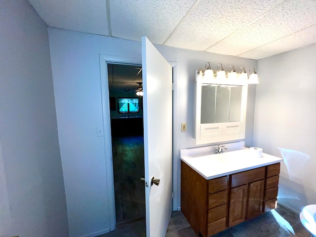 bathroom featuring ceiling fan, vanity, and a paneled ceiling