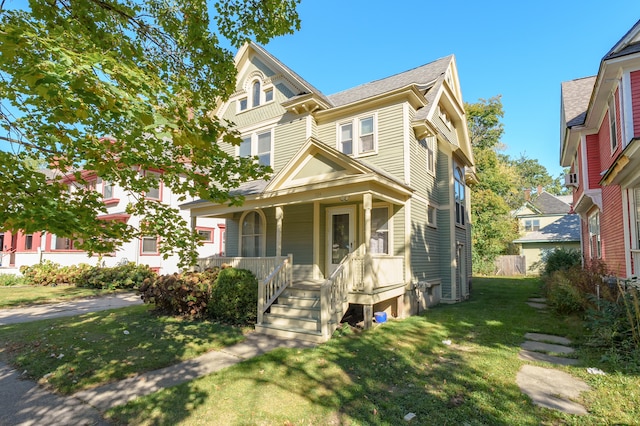 victorian-style house featuring a front lawn and a porch