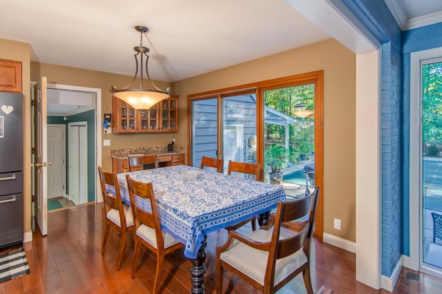 dining room with dark hardwood / wood-style floors and crown molding