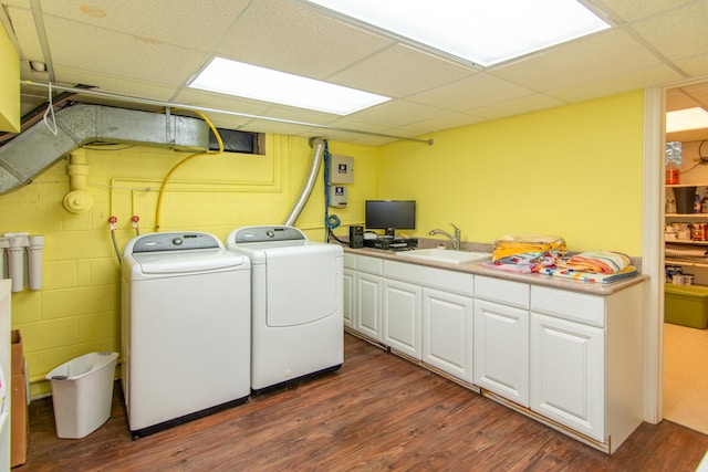 clothes washing area featuring cabinets, washing machine and dryer, dark hardwood / wood-style floors, and sink