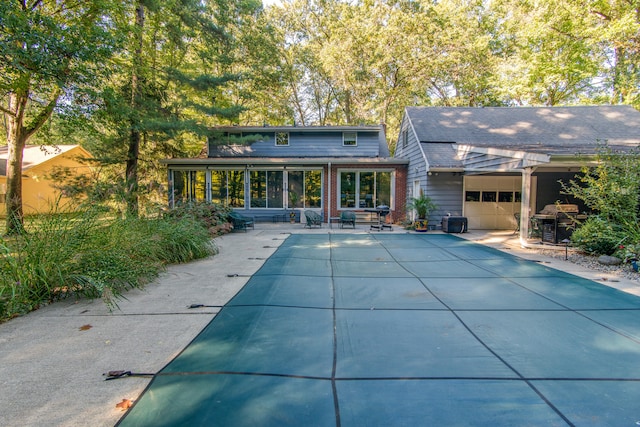 back of house with a patio area, a sunroom, and a garage