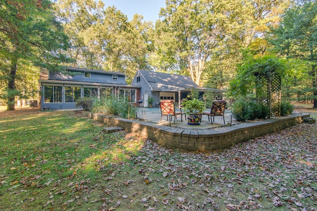 back of house with a sunroom, a lawn, and a patio area