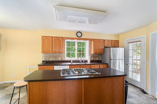 kitchen featuring backsplash, appliances with stainless steel finishes, plenty of natural light, and sink