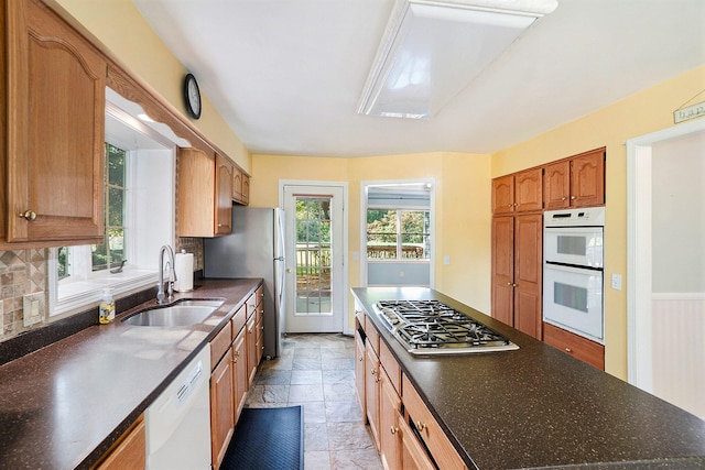 kitchen with decorative backsplash, sink, and stainless steel appliances