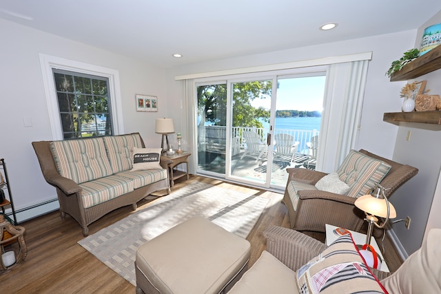 living room featuring a water view, wood-type flooring, and a baseboard radiator