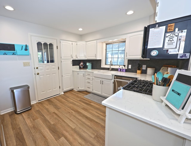 kitchen featuring white cabinets, sink, backsplash, and light hardwood / wood-style floors