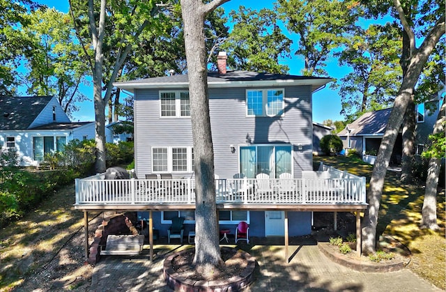 back of house with a deck and a patio