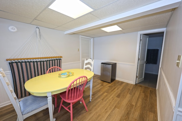 dining space with a paneled ceiling and wood-type flooring