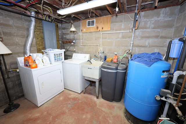 laundry room featuring electric panel, washing machine and clothes dryer, and sink