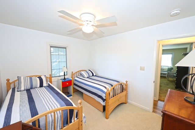 bedroom with ceiling fan and light colored carpet