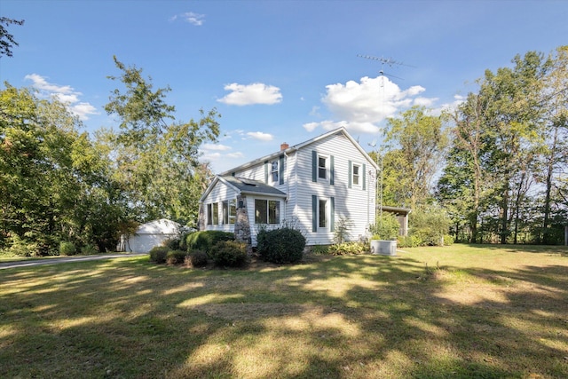 view of front of property with a front yard and central AC