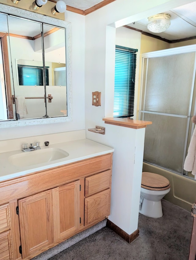 full bathroom featuring ornamental molding, vanity, toilet, and bath / shower combo with glass door