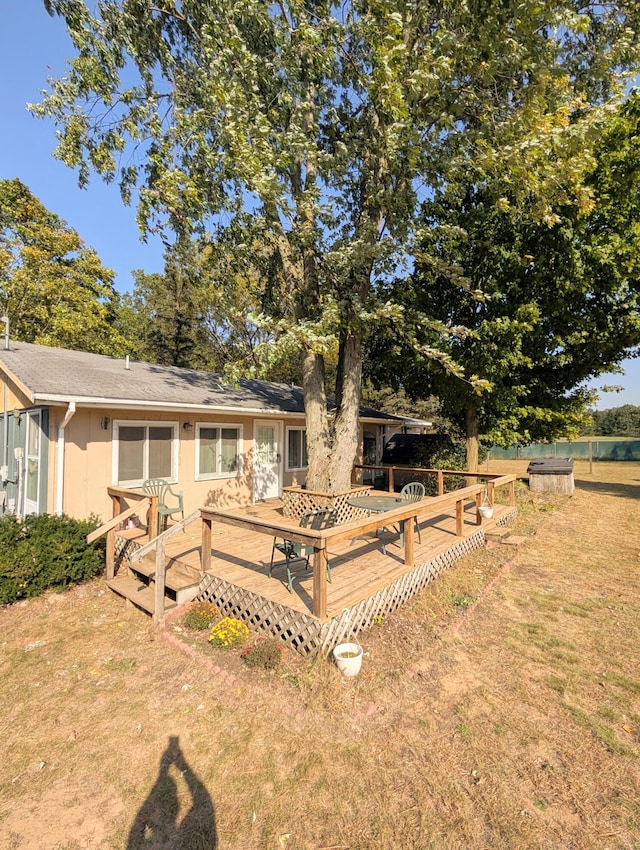 rear view of house with a deck and a yard