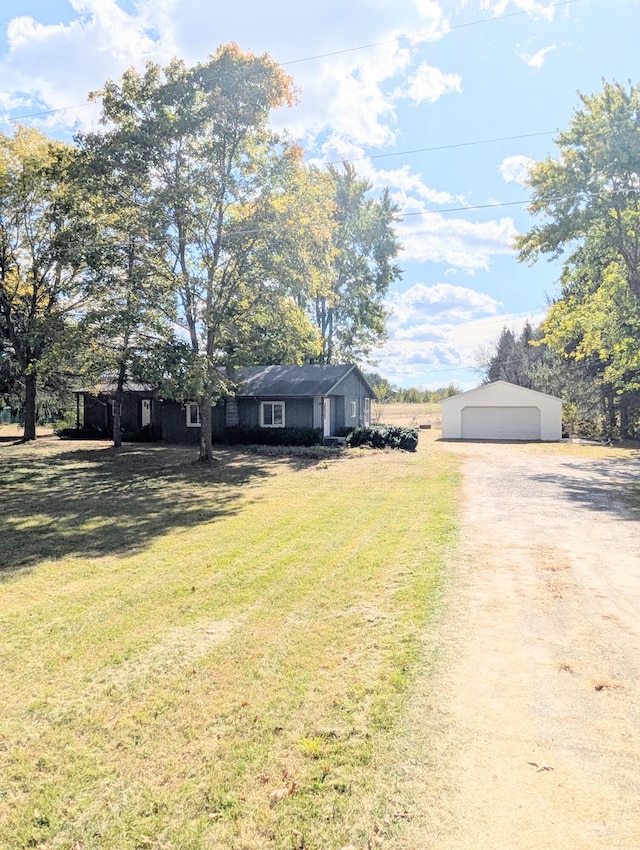 ranch-style house featuring a garage, an outbuilding, and a front lawn