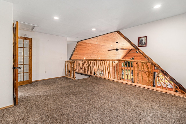 carpeted empty room featuring ceiling fan and wood walls