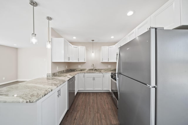 kitchen with white cabinets, kitchen peninsula, decorative light fixtures, appliances with stainless steel finishes, and dark hardwood / wood-style flooring