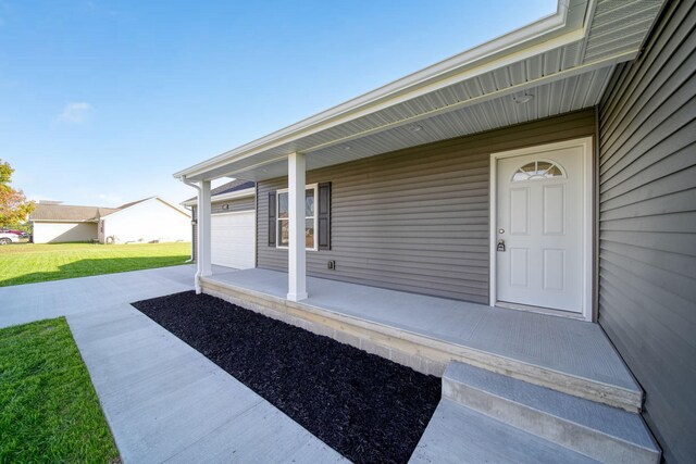 view of exterior entry featuring a yard and a garage