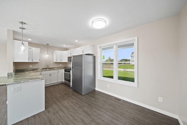 kitchen with white cabinets, appliances with stainless steel finishes, hanging light fixtures, and dark wood-type flooring