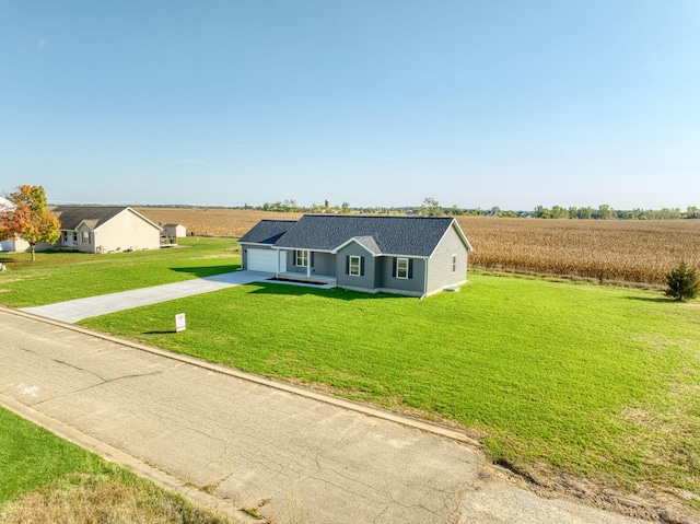 view of front of home with a front yard, a rural view, and a garage