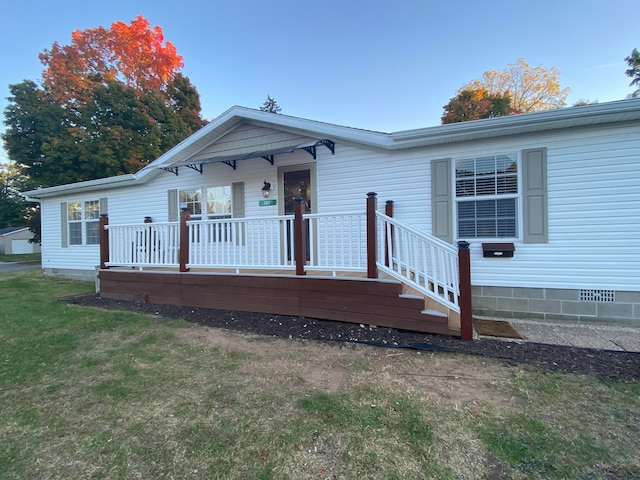 view of front of property featuring a front lawn and a deck