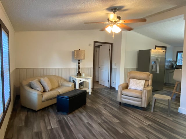 living room featuring ceiling fan, a textured ceiling, lofted ceiling, and dark hardwood / wood-style flooring