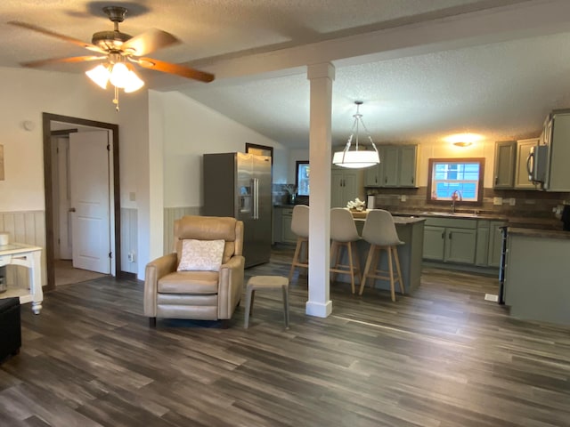 kitchen with backsplash, appliances with stainless steel finishes, ceiling fan, dark wood-type flooring, and green cabinets